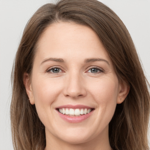 Joyful white young-adult female with long  brown hair and grey eyes