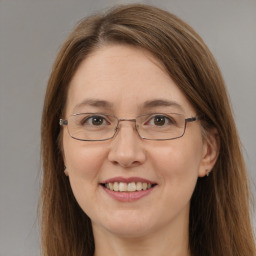 Joyful white adult female with long  brown hair and grey eyes