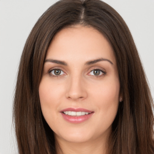 Joyful white young-adult female with long  brown hair and brown eyes