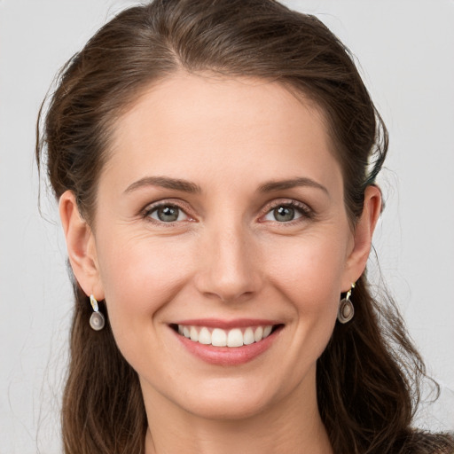 Joyful white young-adult female with long  brown hair and grey eyes