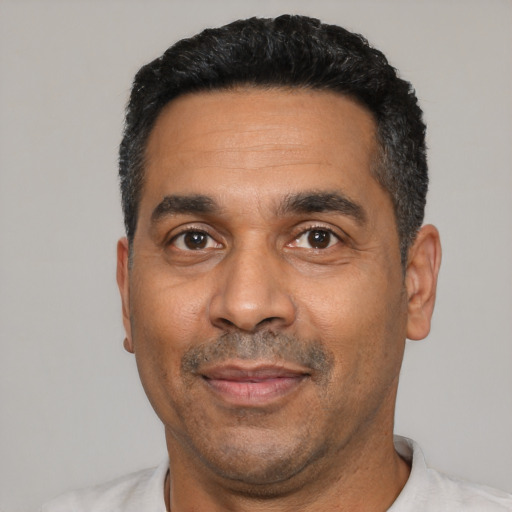 Joyful latino adult male with short  black hair and brown eyes