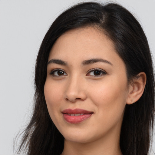 Joyful latino young-adult female with long  brown hair and brown eyes