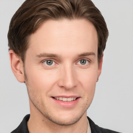 Joyful white young-adult male with short  brown hair and grey eyes