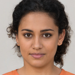 Joyful latino young-adult female with medium  brown hair and brown eyes