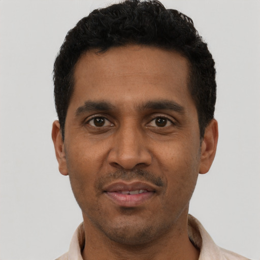 Joyful black young-adult male with short  black hair and brown eyes