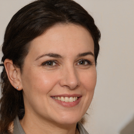 Joyful white adult female with medium  brown hair and brown eyes