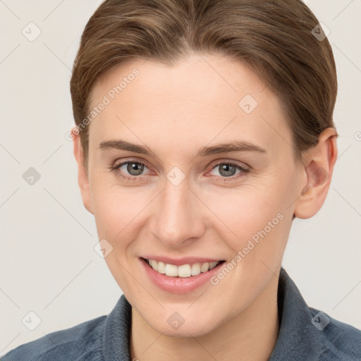 Joyful white young-adult female with short  brown hair and grey eyes