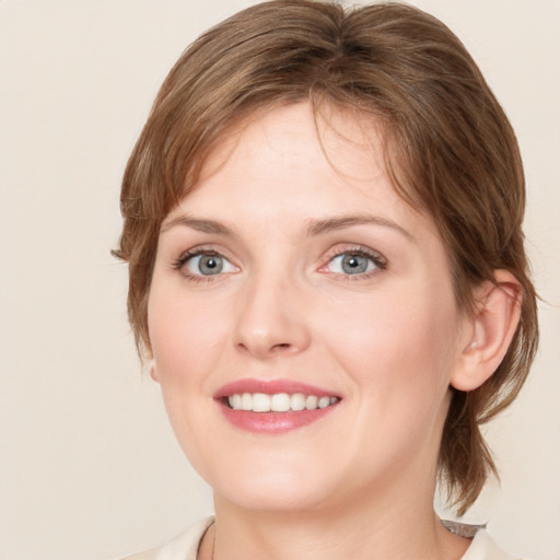 Joyful white young-adult female with medium  brown hair and blue eyes