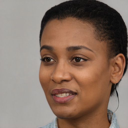 Joyful black young-adult female with short  black hair and brown eyes