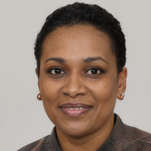 Joyful black adult female with short  black hair and brown eyes