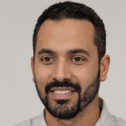 Joyful latino young-adult male with short  black hair and brown eyes