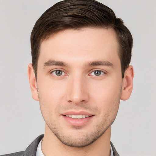 Joyful white young-adult male with short  brown hair and grey eyes