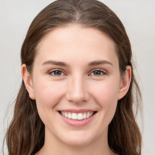 Joyful white young-adult female with long  brown hair and grey eyes