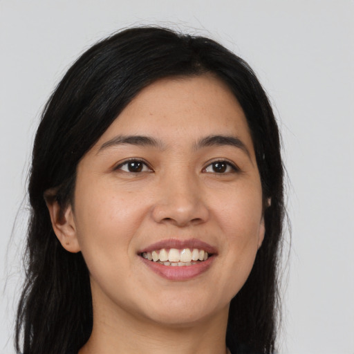Joyful asian young-adult female with long  brown hair and brown eyes