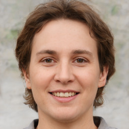 Joyful white young-adult female with medium  brown hair and grey eyes