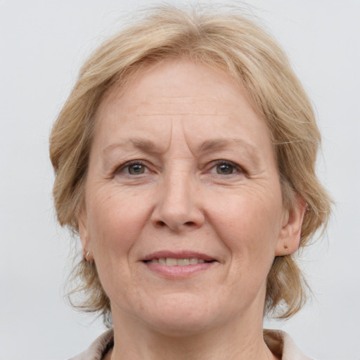 Joyful white middle-aged female with medium  brown hair and grey eyes