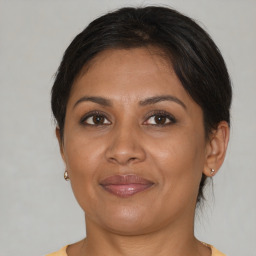 Joyful latino adult female with medium  brown hair and brown eyes