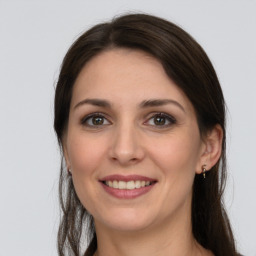 Joyful white young-adult female with long  brown hair and grey eyes