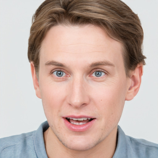 Joyful white young-adult male with short  brown hair and blue eyes