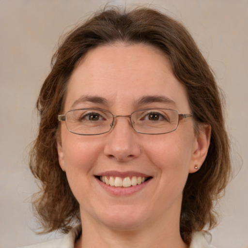 Joyful white adult female with medium  brown hair and green eyes