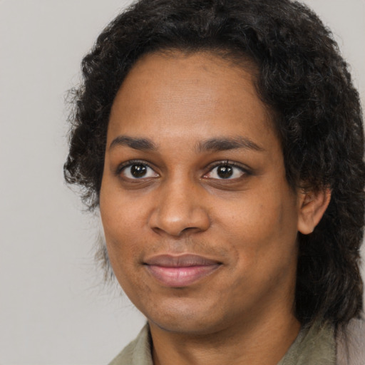 Joyful black young-adult female with long  black hair and brown eyes