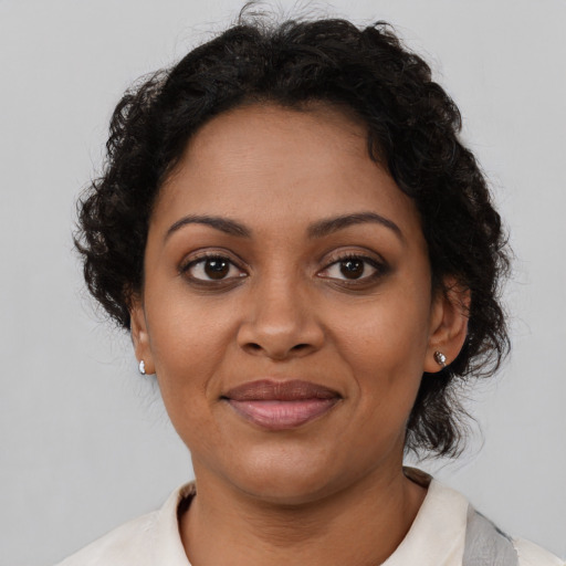 Joyful black young-adult female with short  brown hair and brown eyes