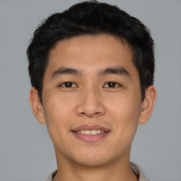 Joyful asian young-adult male with short  black hair and brown eyes