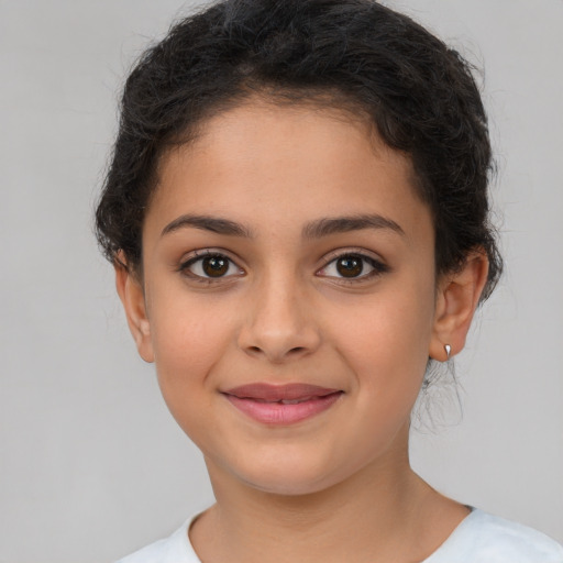 Joyful latino child female with short  brown hair and brown eyes