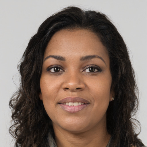 Joyful black young-adult female with long  brown hair and brown eyes