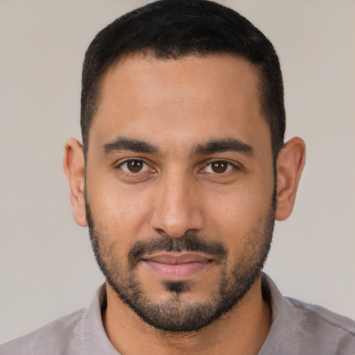 Joyful latino young-adult male with short  black hair and brown eyes