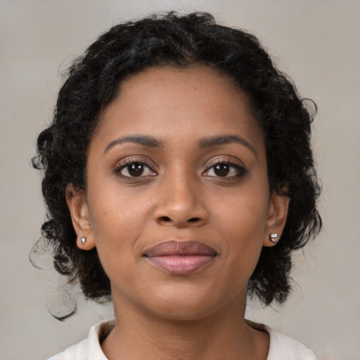 Joyful black young-adult female with medium  brown hair and brown eyes