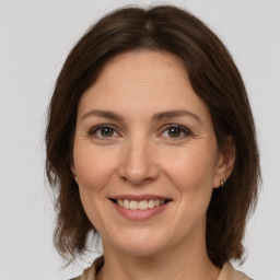 Joyful white adult female with medium  brown hair and grey eyes