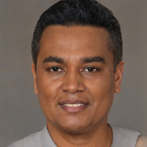 Joyful latino adult male with short  black hair and brown eyes