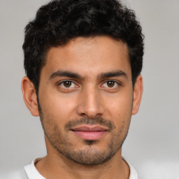 Joyful latino young-adult male with short  brown hair and brown eyes