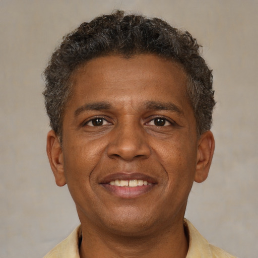 Joyful black adult male with short  brown hair and brown eyes