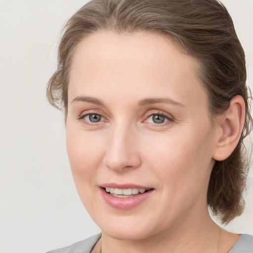 Joyful white young-adult female with medium  brown hair and blue eyes