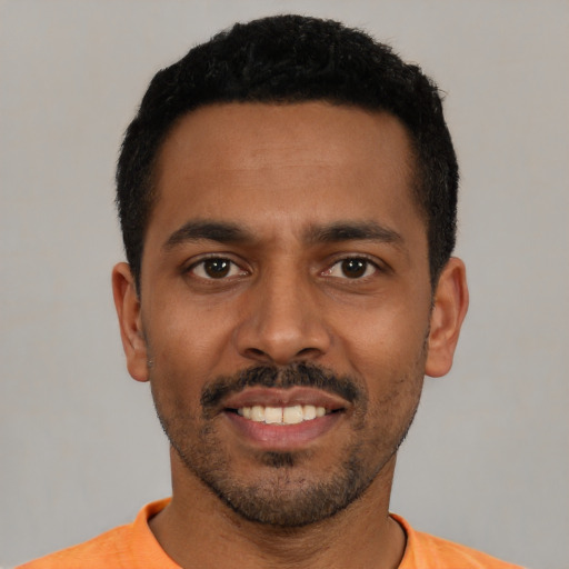 Joyful black young-adult male with short  black hair and brown eyes