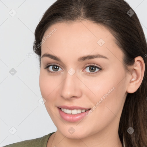 Joyful white young-adult female with long  brown hair and grey eyes