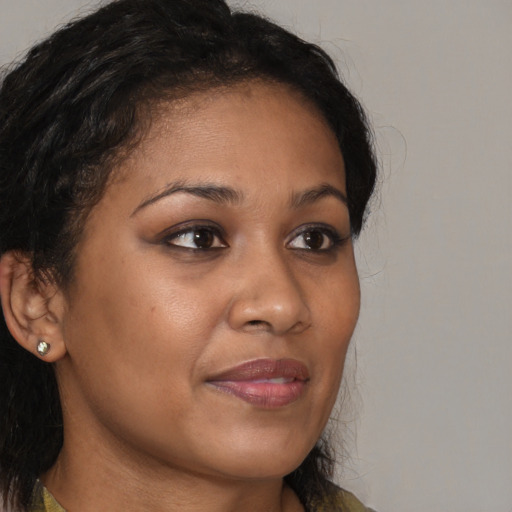 Joyful black young-adult female with long  brown hair and brown eyes