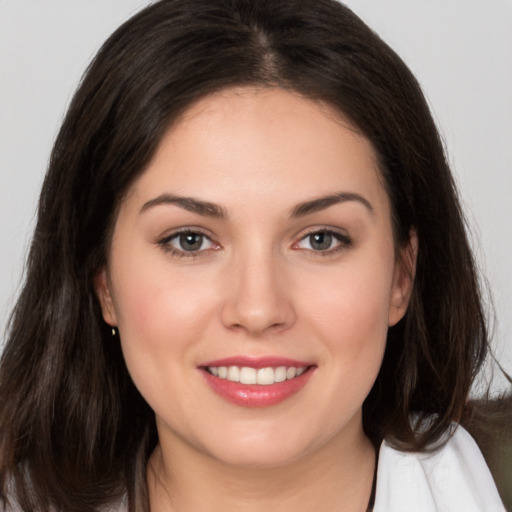 Joyful white young-adult female with long  brown hair and brown eyes