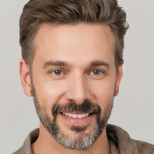 Joyful white adult male with short  brown hair and brown eyes