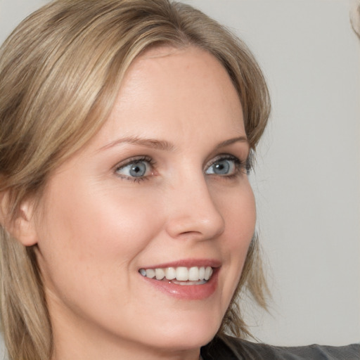 Joyful white young-adult female with medium  brown hair and blue eyes