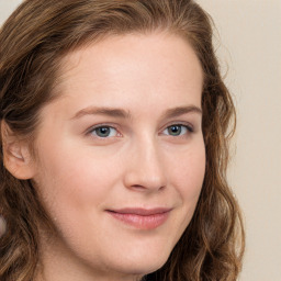 Joyful white young-adult female with long  brown hair and blue eyes