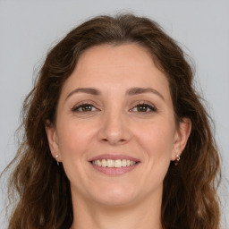 Joyful white adult female with long  brown hair and brown eyes