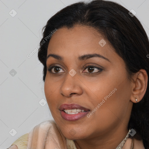 Joyful black young-adult female with long  brown hair and brown eyes