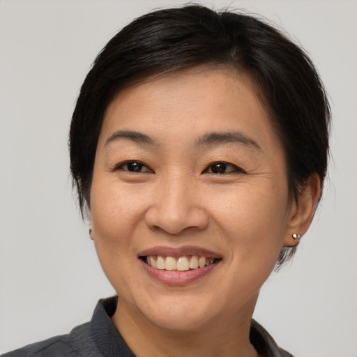 Joyful asian young-adult female with medium  brown hair and brown eyes