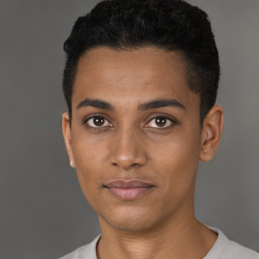 Joyful black young-adult male with short  black hair and brown eyes