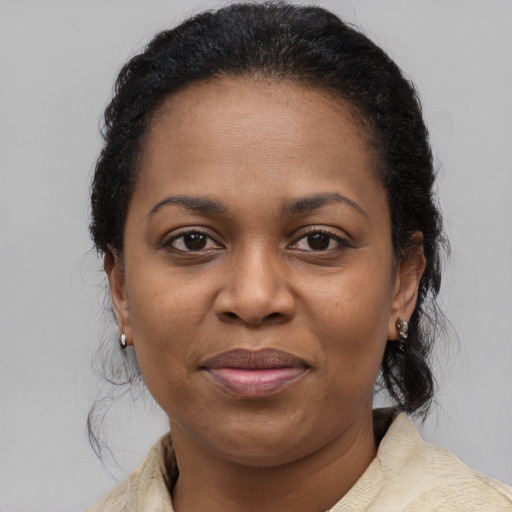 Joyful black adult female with medium  brown hair and brown eyes