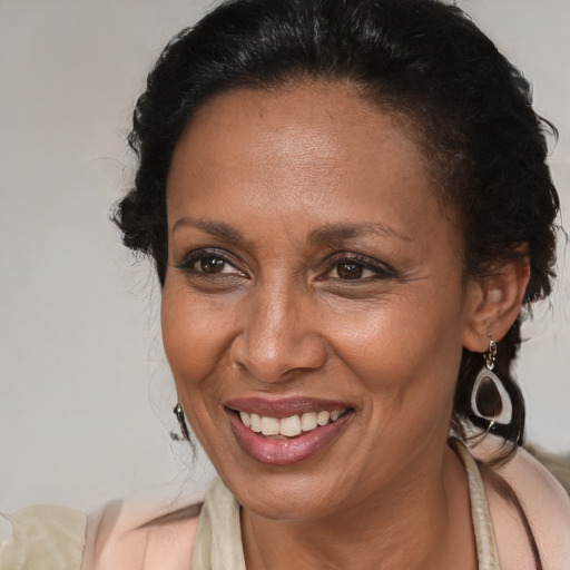 Joyful black adult female with medium  brown hair and brown eyes