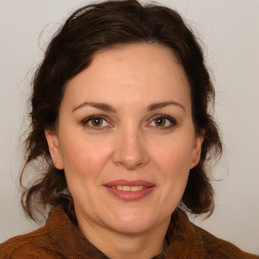 Joyful white adult female with medium  brown hair and green eyes